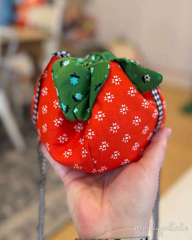 Woollypetals Strawberry Friends red fabric strawberry with green leaves held in hand