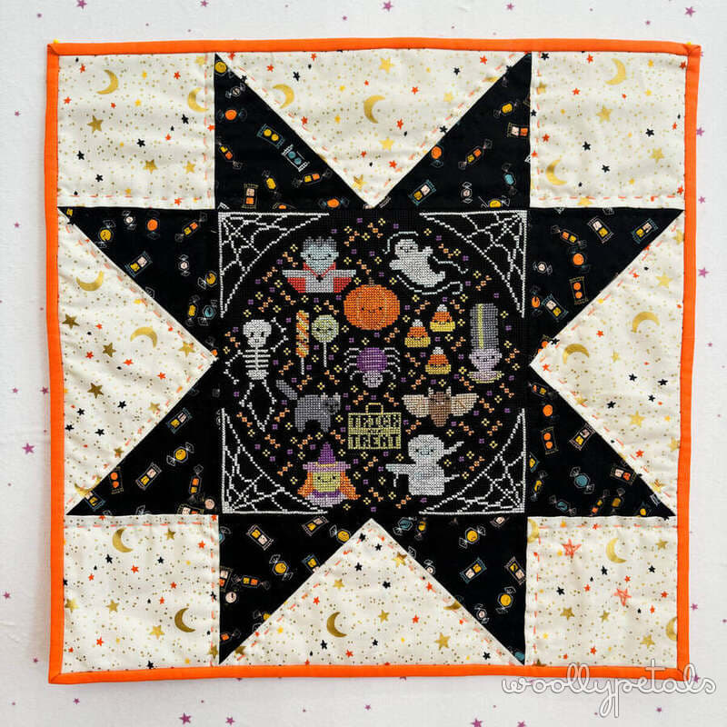 Sawtooth Star mini quilt with cross stitch center and Halloween fabrics
