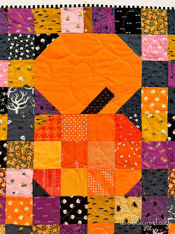 Woollypetals Ghost Party Pumpkins quilt with orange pumpkin blocks on colorful patchwork