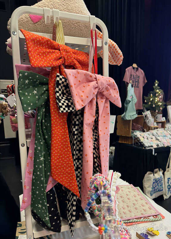 Woollypetals hanging bow tutorial displayed on white ladder rack with fabric samples