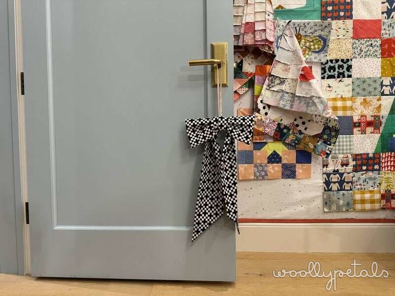 Woollypetals hanging bow tutorial with black and white checkered bow on gray door