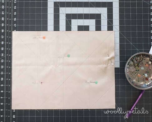 Woollypetals HST grid method tutorial showing drawn diagonal lines on fabric with pins