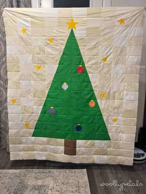 Woollypetals Oh Christmas Tree quilt with green tree, yellow stars, and colorful ornaments