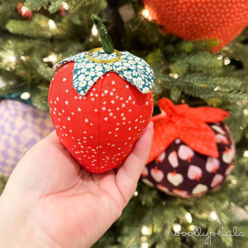 Woollypetals Strawberry Pillow Pattern ornament held in hand on Christmas tree
