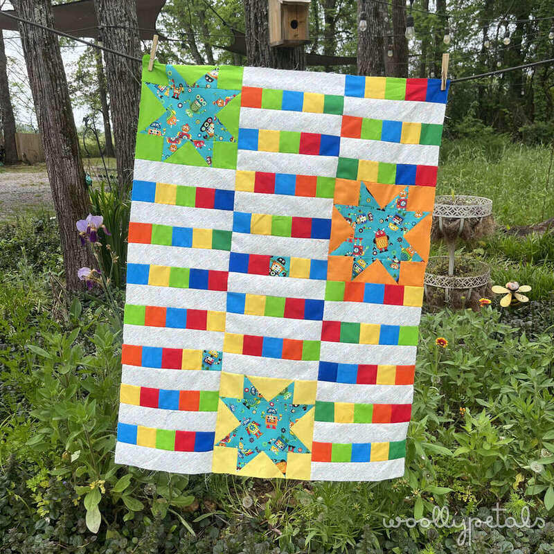 Woollypetals StarBeam quilt with colorful star blocks and striped rows