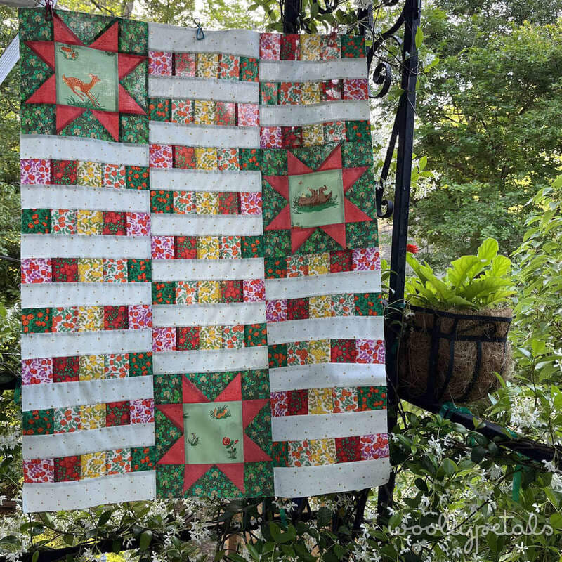 Woollypetals StarBeam quilt in throw size with red stars and colorful fabric strips