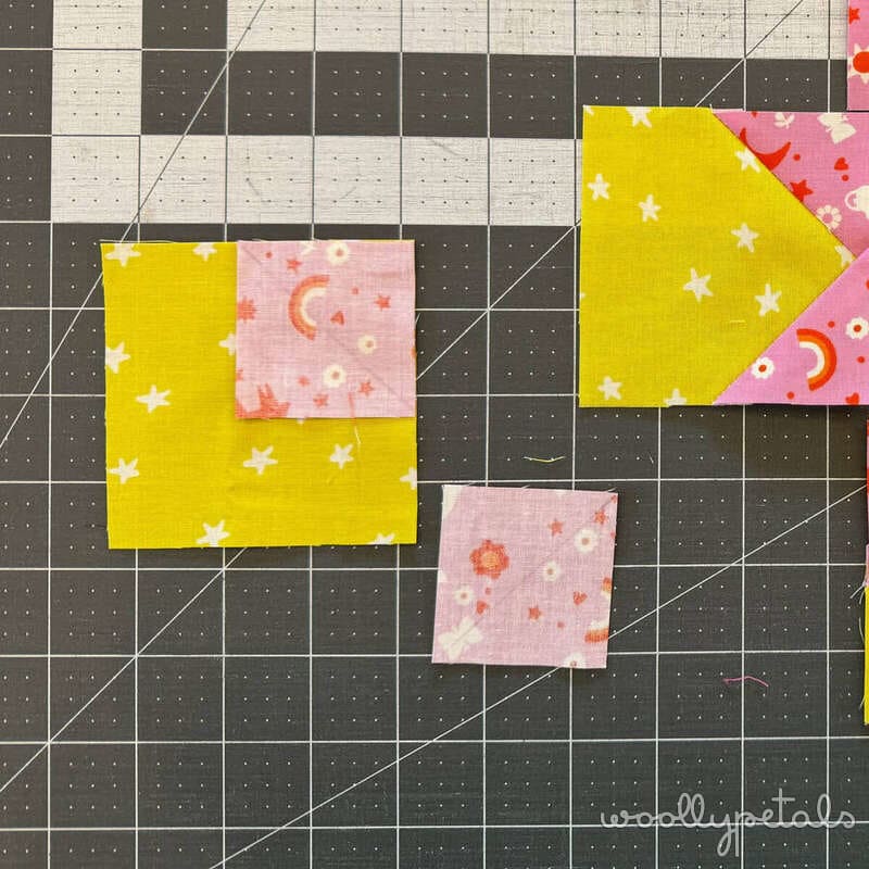 Woollypetals New Star quilt fabric squares showing Stitch'N'Flip technique with yellow and pink star fabrics on cutting mat