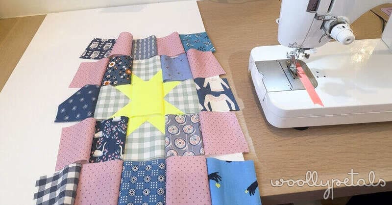 Woollypetals New Star quilt block layout with pink, navy, and yellow fabric pieces