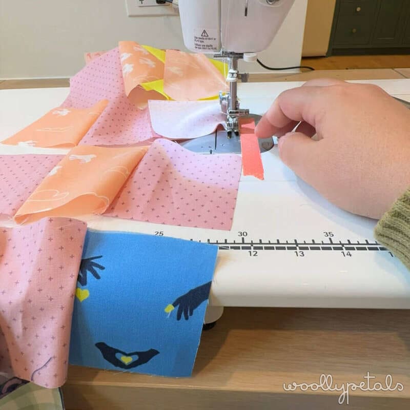 Woollypetals New Star quilt block being sewn on machine with pink and orange fabrics