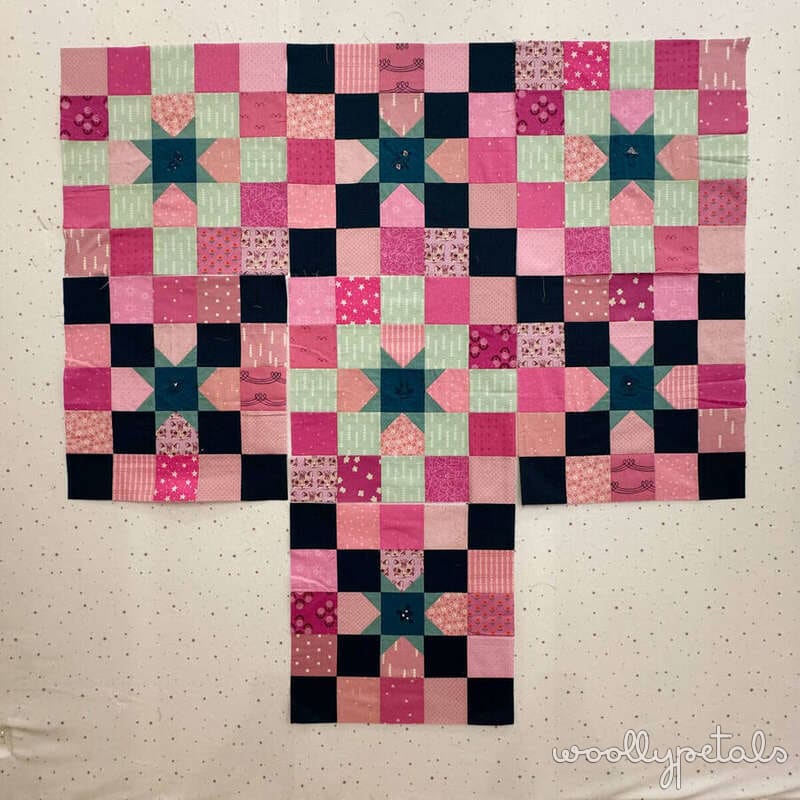 Woollypetals New Star quilt top layout in pink, black, and green fabrics