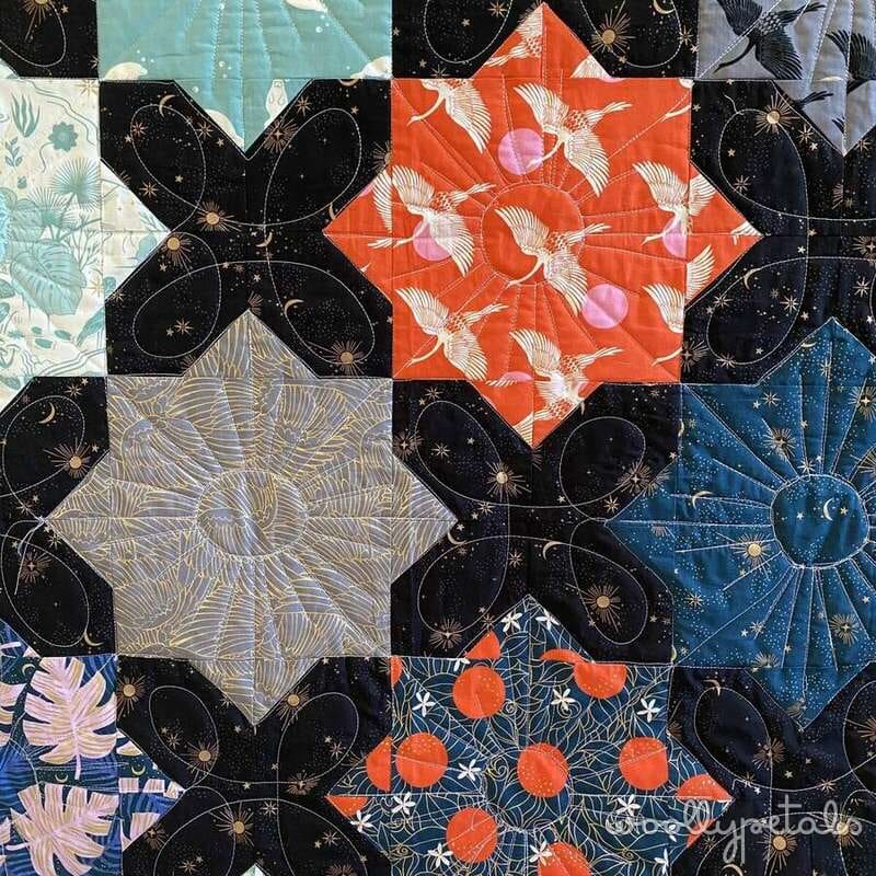 Woollypetals quilt with black celestial blocks and colorful patterned squares