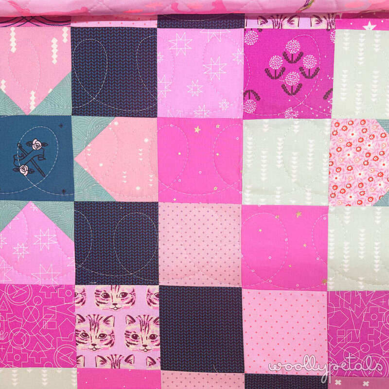 Woollypetals quilt with patchwork squares in pink, navy, and cream fabrics