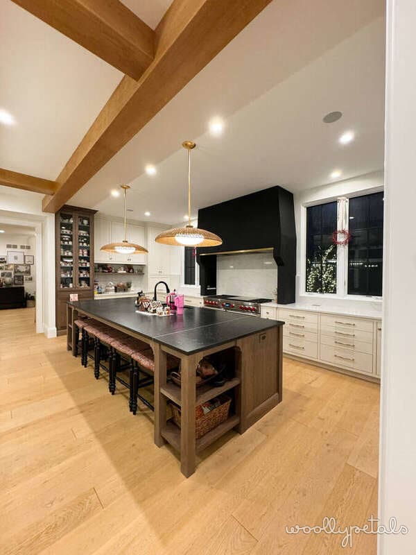 Modern kitchen with wooden beams, island seating, and pendant lighting