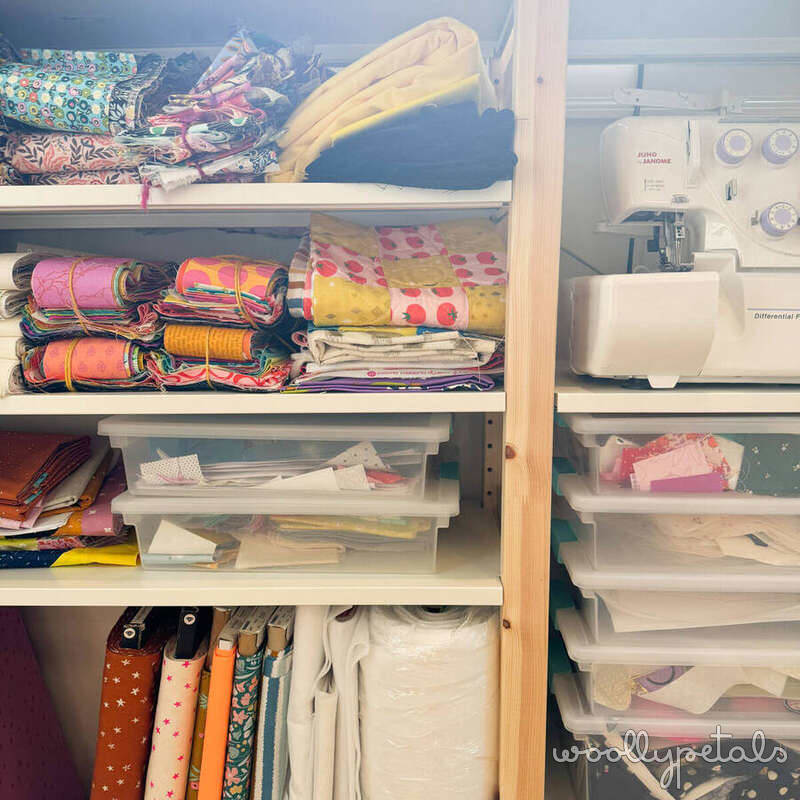 Sewing room shelving with organized fabric, notions, and sewing machine