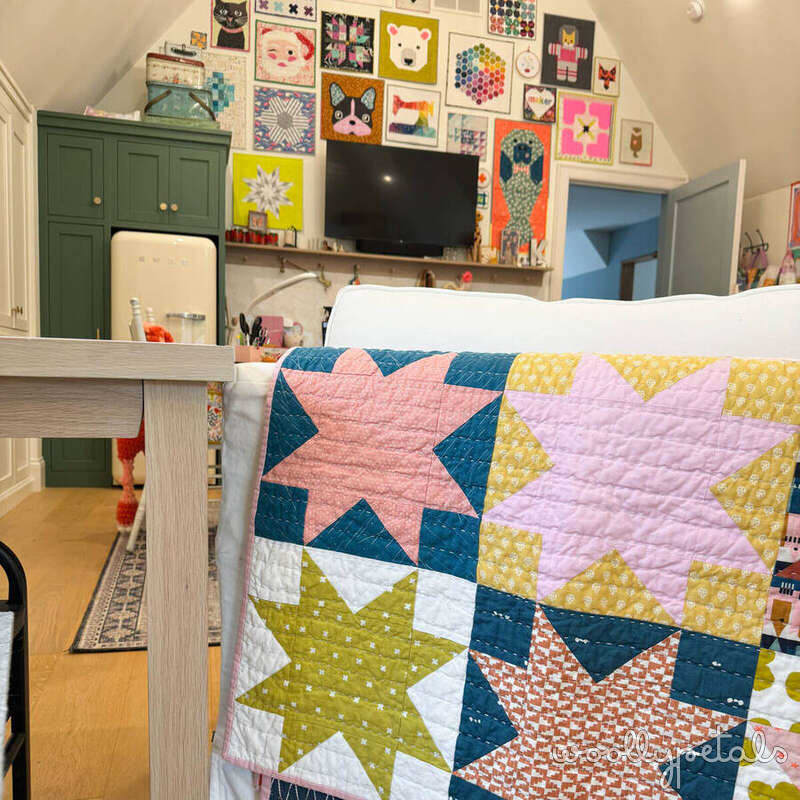 Colorful patchwork quilt with star blocks in pink, blue, yellow, and coral fabrics