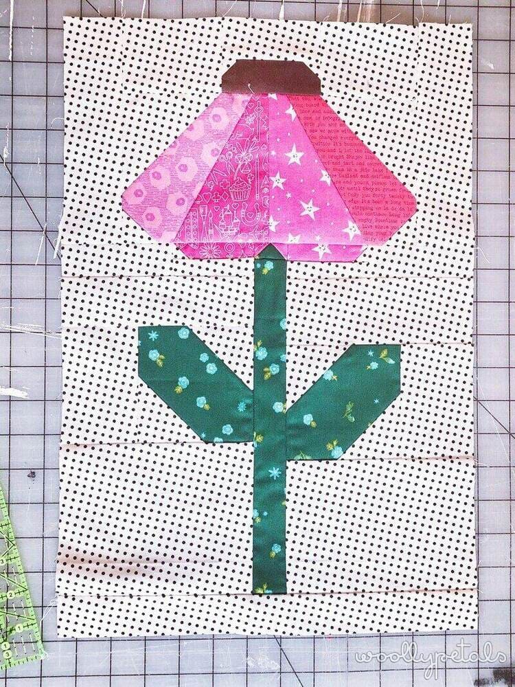 Woollypetals Echinacea Quilt Block with pink petal and green stem on polka dot background