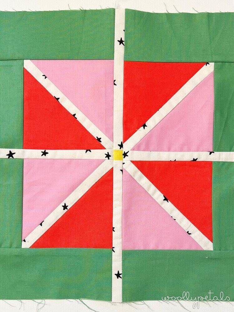 Woollypetals StarFlake Quilt Block in red, pink, and green fabrics