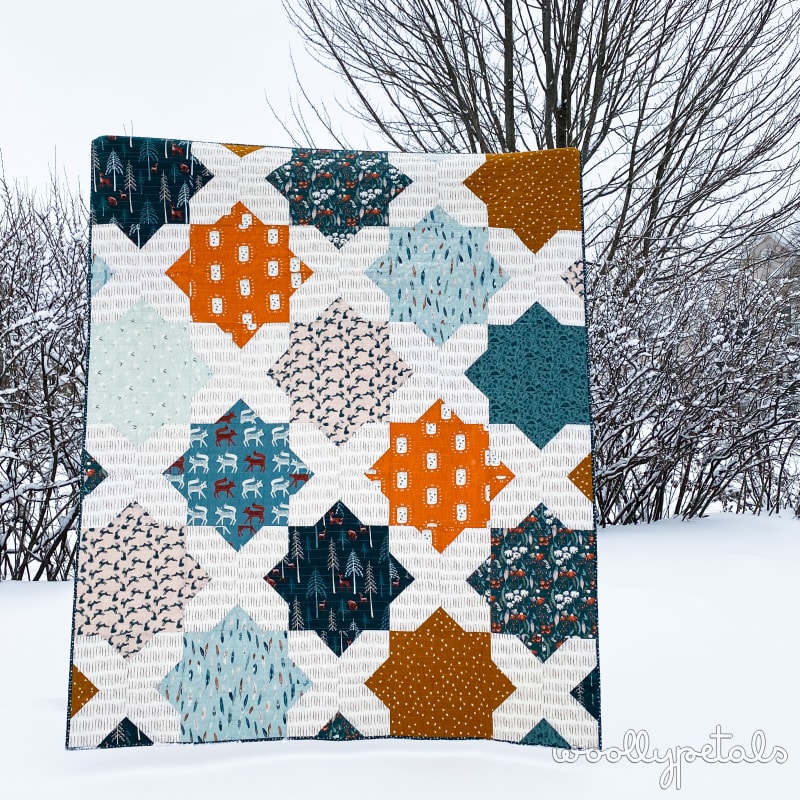 Woollypetals Floored quilt in orange, blue, and cream with diamond-shaped blocks
