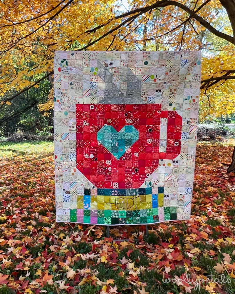 Woollypetals Book Date Patchwork Quilt with heart design displayed outdoors