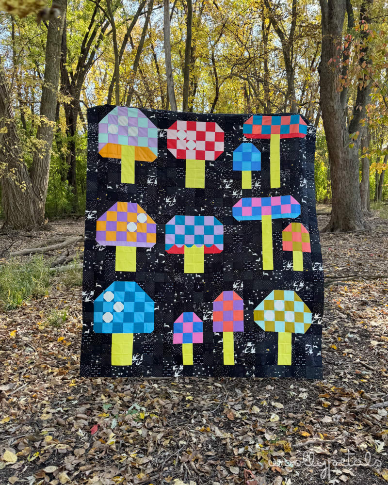 Woollypetals Capped quilt with colorful checkered mushroom blocks on black background