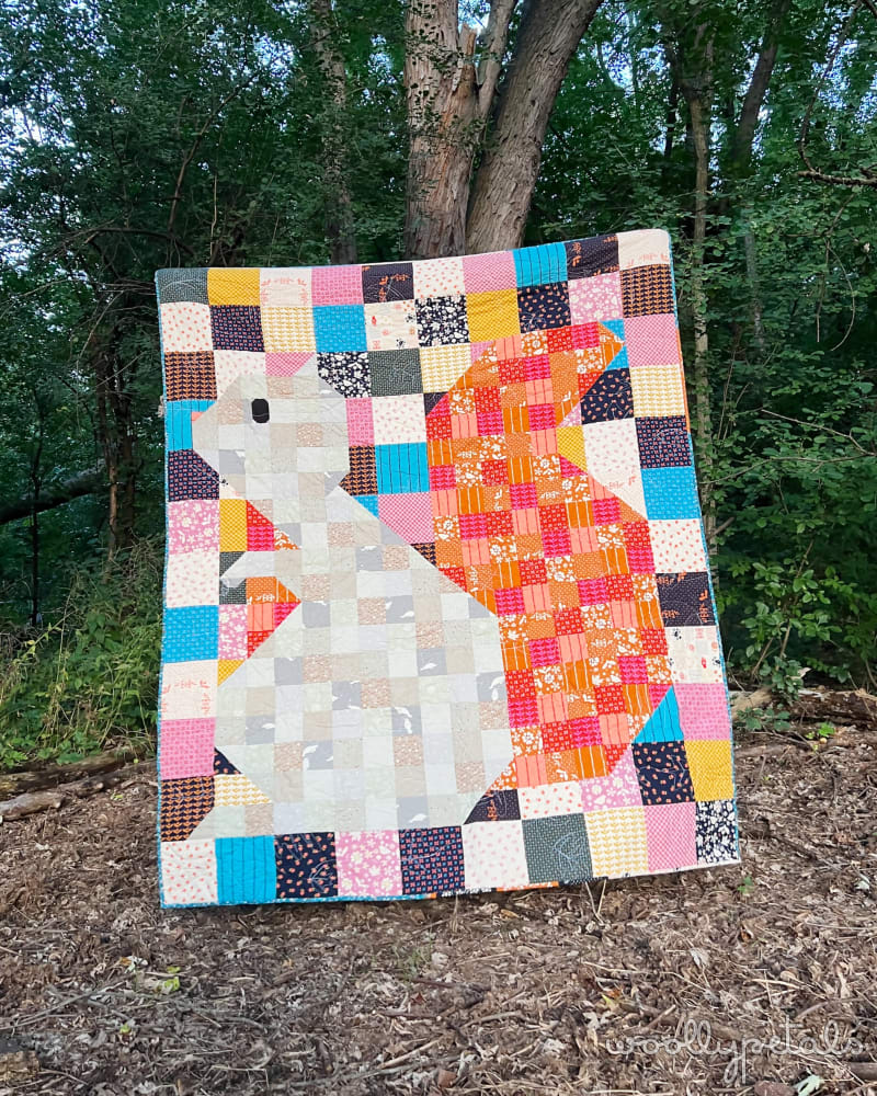 Woollypetals Squirrel quilt with colorful patchwork border and orange center design